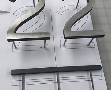 brushed aluminum interior letterset for elevator jamb ID.  modern sans serif font